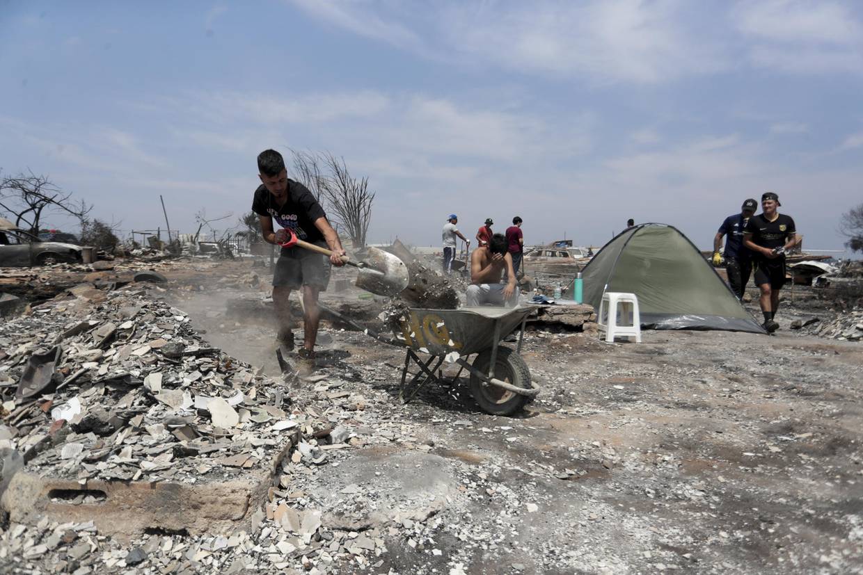 Personas del campamento irregular “Pompeya” recogen escombros, tras los incendios del día viernes 2 de febrero, en la zona de Viña del Mar, Región de Valparaiso (Chile). EFE/ Ailen Díaz