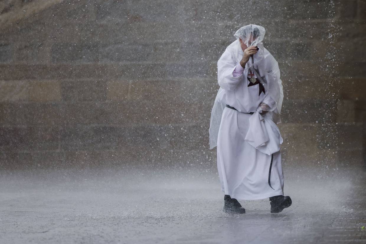 Imagen ilustrativa de lluvias, un religioso se cubre de un fuerte diluvio.  | EFE/Lavandeira jr