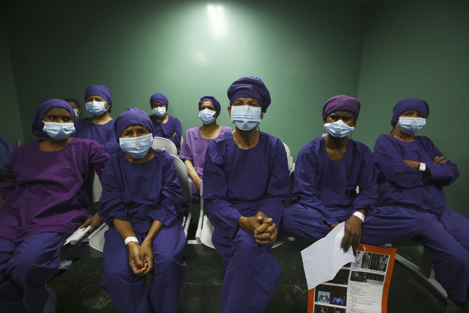 Una decena de pacientes espera ser anestesiada antes de ser operada de cataratas por el equipo del doctor Sanduk Ruit en un centro médico de Katmandú, Nepal, el 26 de marzo del 2021. (AP Photo/Niranjan Shrestha)
