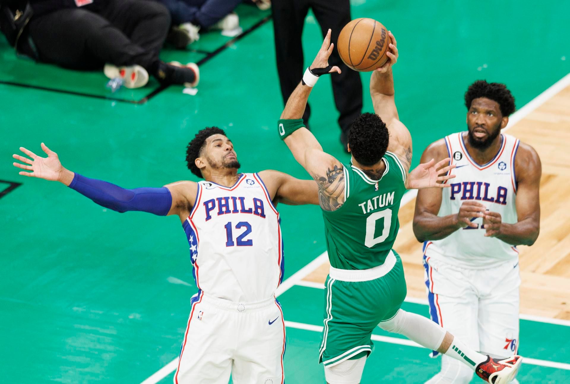 El alero de los Celtics Jayson Tatum (c) dispara sobre el delantero defensor de los 76ers Tobias Harris (i) y el centro de los 76ers Joel Embiid (d). EFE/EPA/CJ GUNTHER
