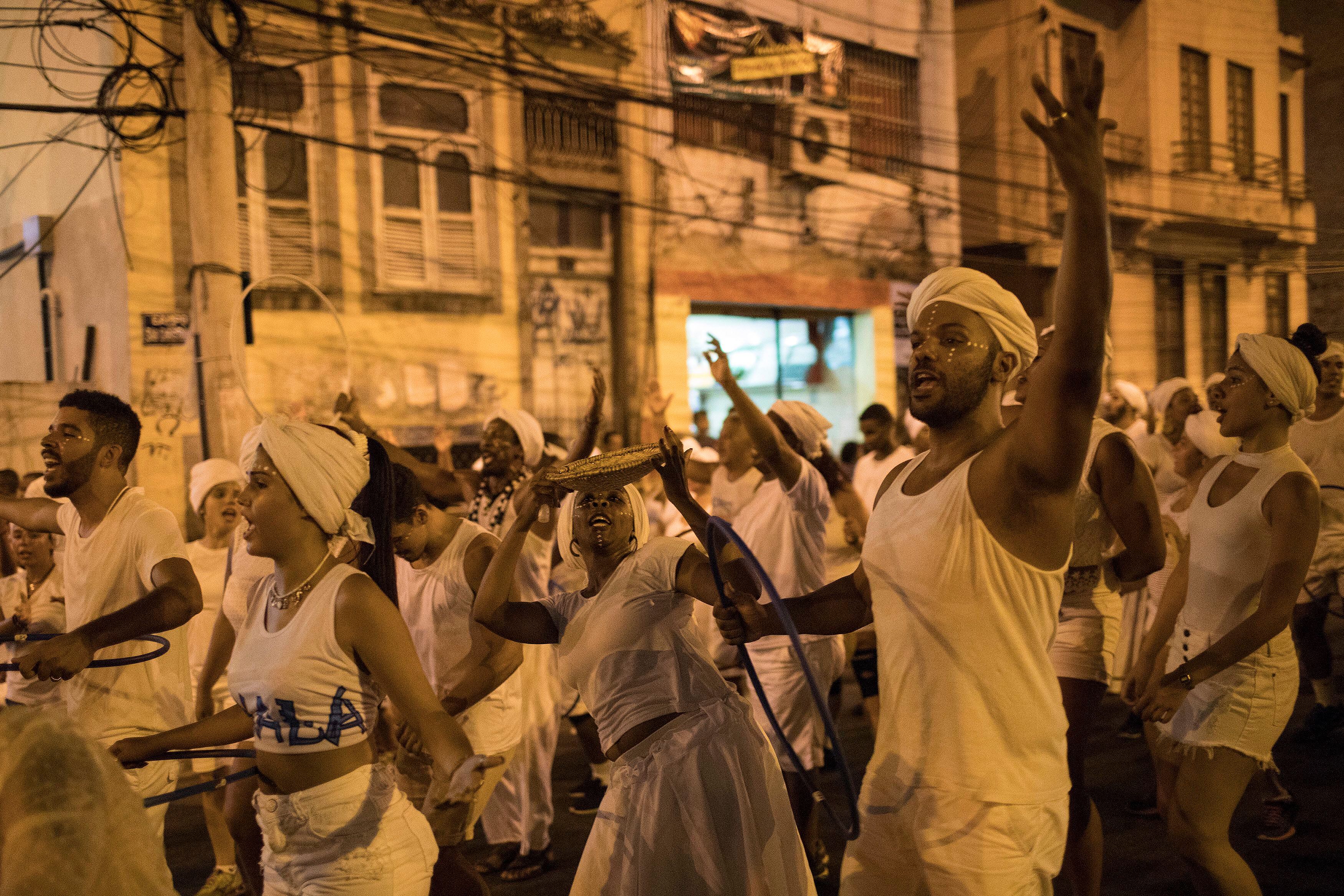 In this Jan. 22, 2018 photo, members of the Paraiso do Tuiuti samba school rehearse their dances and songs that make reference to Brazil's history with slavery, in the streets of Rio de Janeiro, Brazil. "It's not just racism against blacks or whites," said Dandara Silva, a hairdresser and dancer in the group. "There is a form of social slavery and we are fighting against that." (AP Photo/Leo Correa)