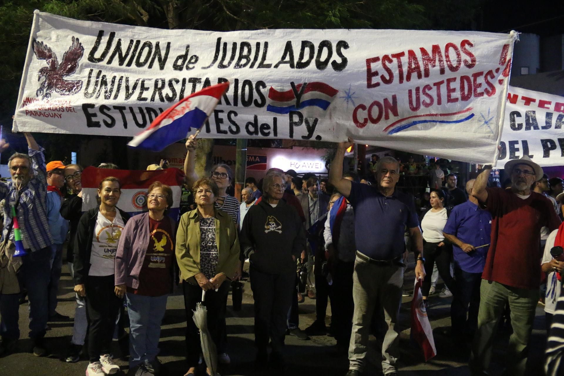 Integrantes de la Unión de Jubilados de Paraguay participan en una manifestación de estudiantes que exigen que se garanticen los recursos que financien el programa 'Arancel Cero', este martes en Asunción (Paraguay). EFE/ Nina Osorio