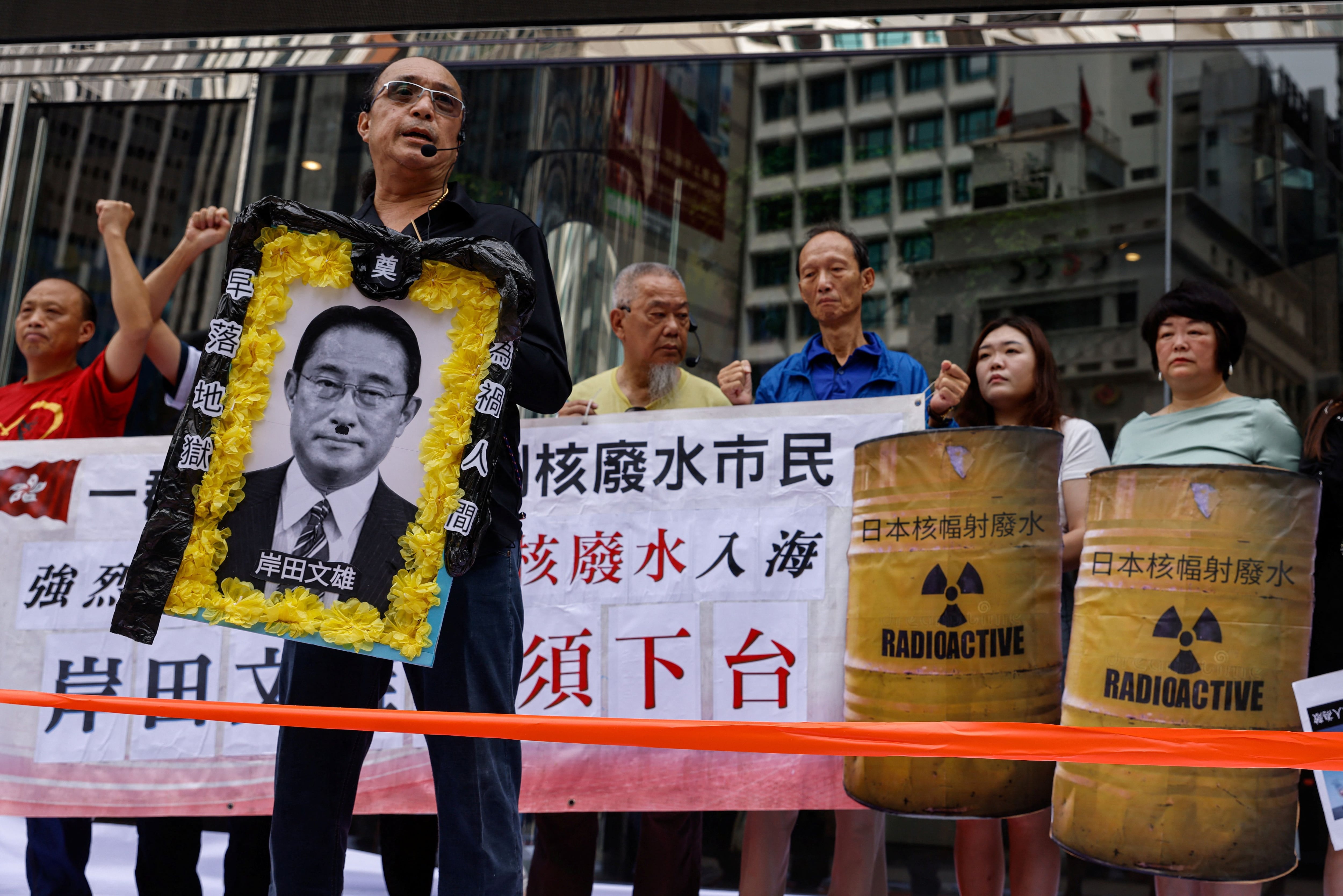 Un manifestante sostiene una imagen del primer ministro de Japón, Fumio Kishida, durante una protesta tras el anuncio de Japón de verter al mar agua radiactiva tratada procedente de la central nuclear de Fukushima, en Hong Kong, China. 24 de agosto de 2023. REUTERS/Tyrone Siu