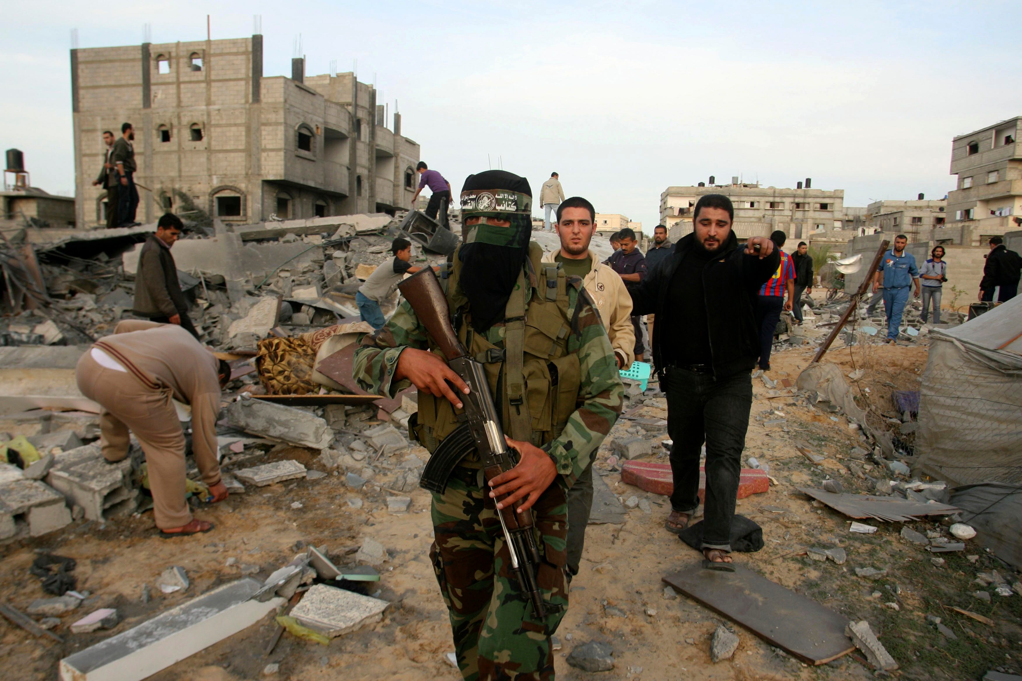 A Palestinian Hamas militant walks in the rubble of the destroyed house of Hamas militant Mohammad Abu Shmala, following an Israeli air strike in Rafah, southern Gaza Strip, Friday, Nov. 16, 2012.(AP Photo/Eyad Baba)