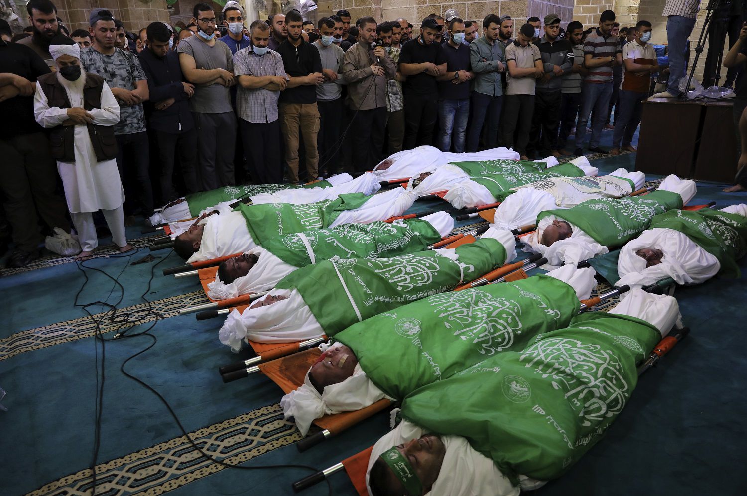 Un grupo de palestinos presencia los funerales de 13 milicianos de Hamas el jueves 13 de mayo de 2021, en Gaza. Los hombres murieron en los enfrentamientos con Israel, (AP Foto/Adel Hana)