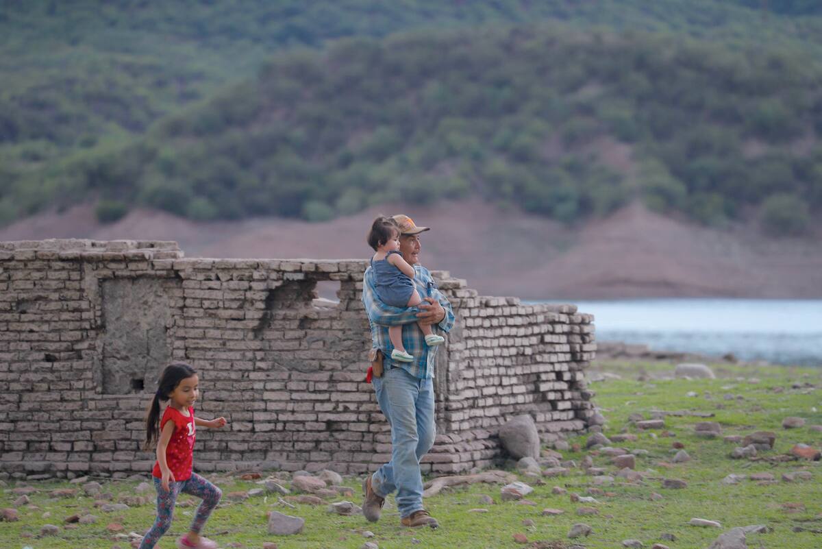 Luis Velázquez camina con sus nietas en las ruinas de Batuc.