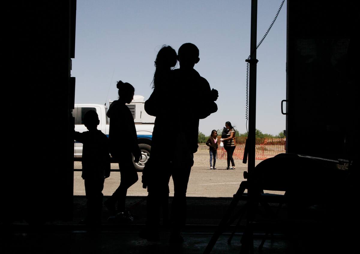 ARCHIVO - Esta foto de archivo del miércoles 22 de mayo del 2019 muestra a migrantes, mayormente de Centroamérica, en un hangar en Deming, Nuevo México. (AP Foto/Cedar Attanasio, Archivo)