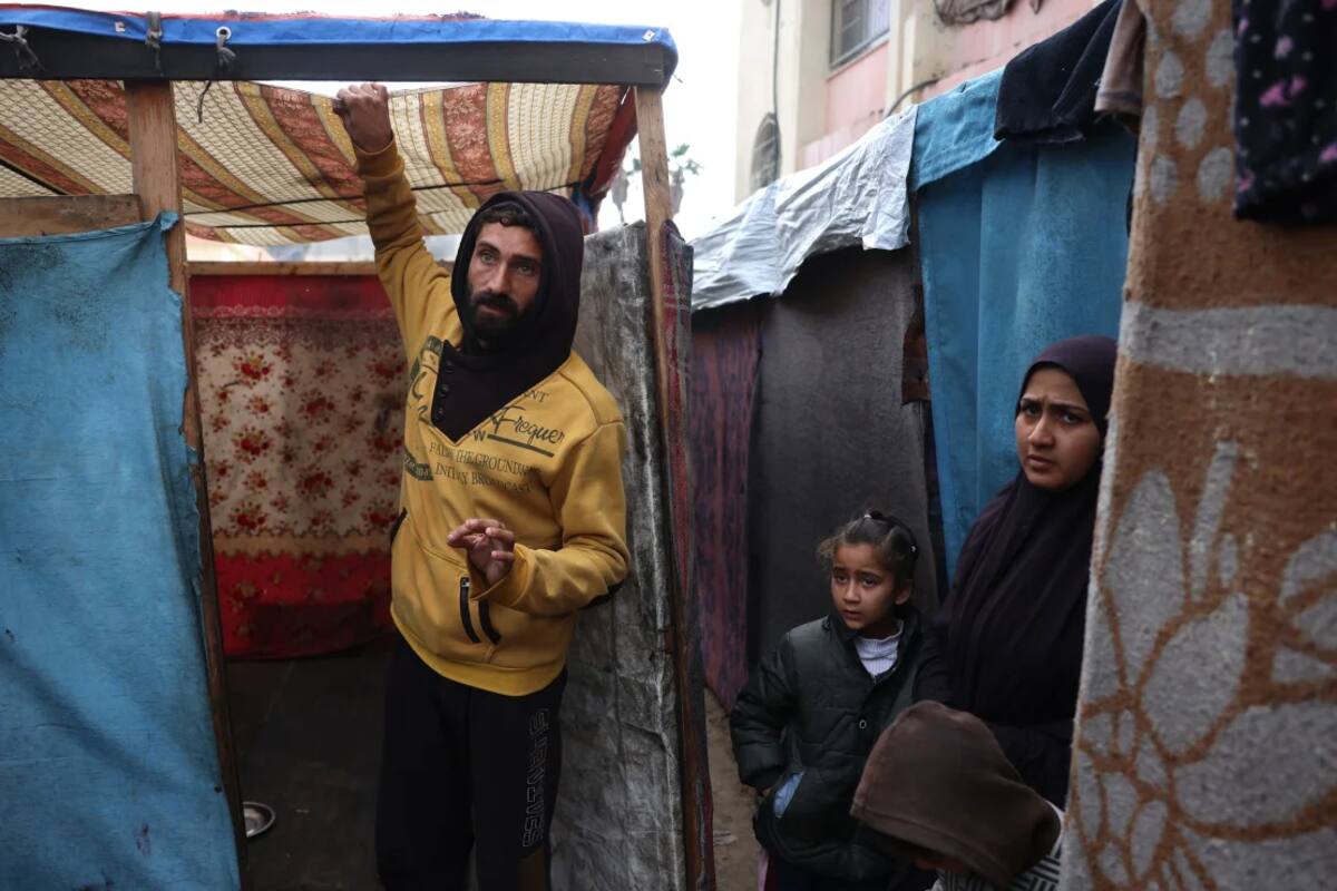 Los palestinos inspeccionan el agua acumulada en el techo de su refugio en un campamento improvisado que alberga a personas desplazadas en Khan Younis, Gaza, el martes. Bashar Taleb/AFP/Getty Images