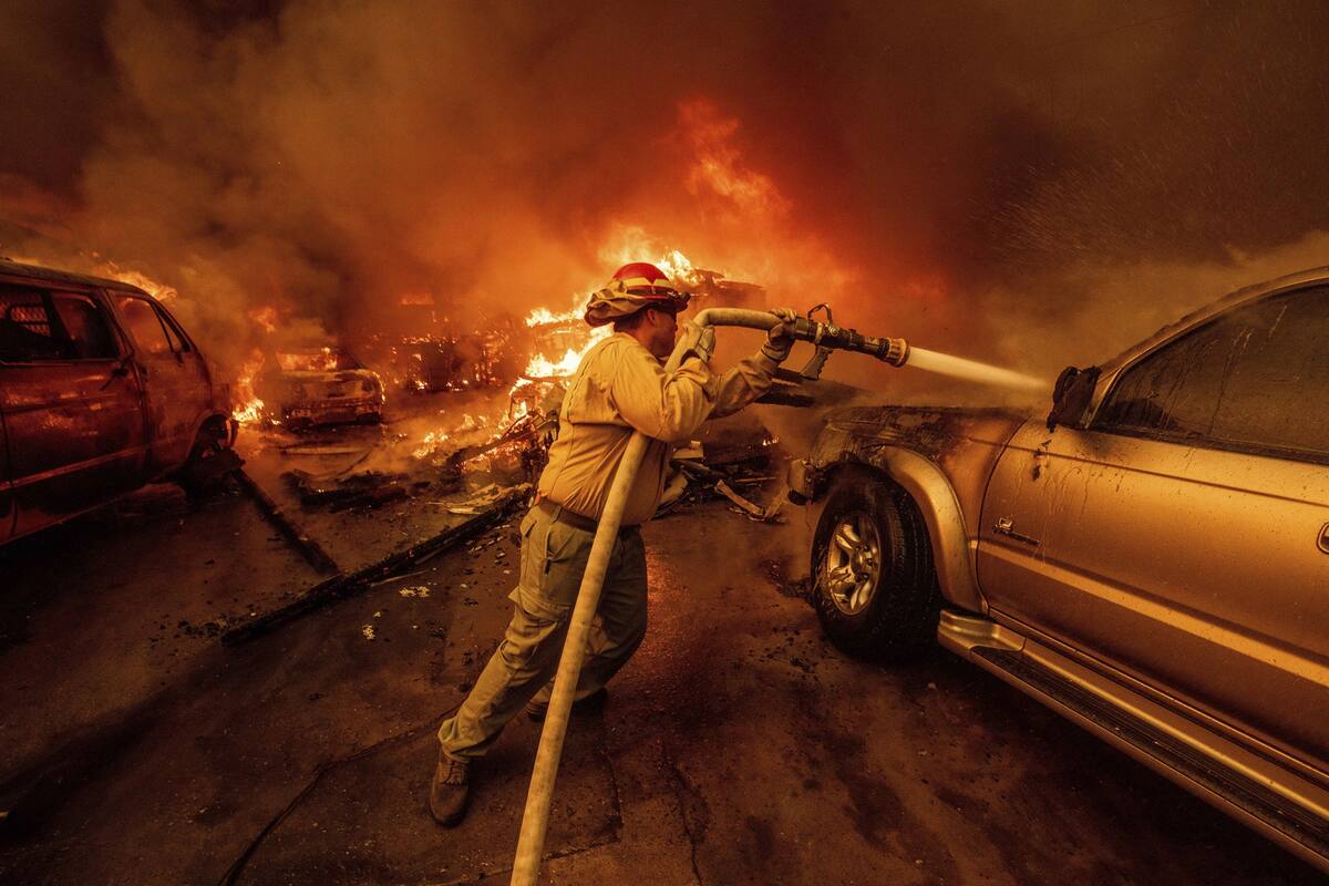 Un bombero apaga vehículos en Altadena, California, durante el incendio de Eaton el miércoles. AP