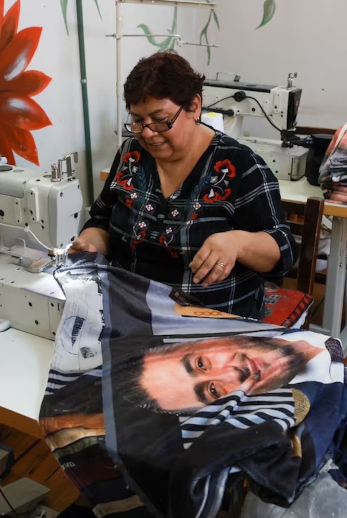 Teresa García, de 59 años, cose una manta con la imagen del ministro de Seguridad de México, Omar García Harfuch, de 44 años, cuya popularidad se disparó tras la muerte del líder del cártel El Mencho, en una tienda de la Ciudad de México, México, el 12 de marzo de 2026. REUTERS/Henry Romero.