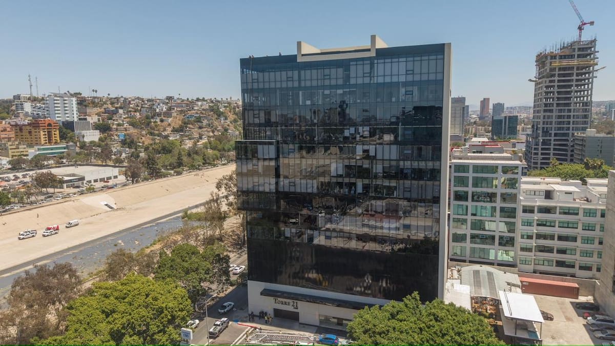 El trabajador realizaba labores de limpieza en la fachada del edificio cuando una cuerda presentó una falla; su sistema de seguridad evitó una caída y permitió que descendiera sin lesiones. Foto: Border Zoom.
