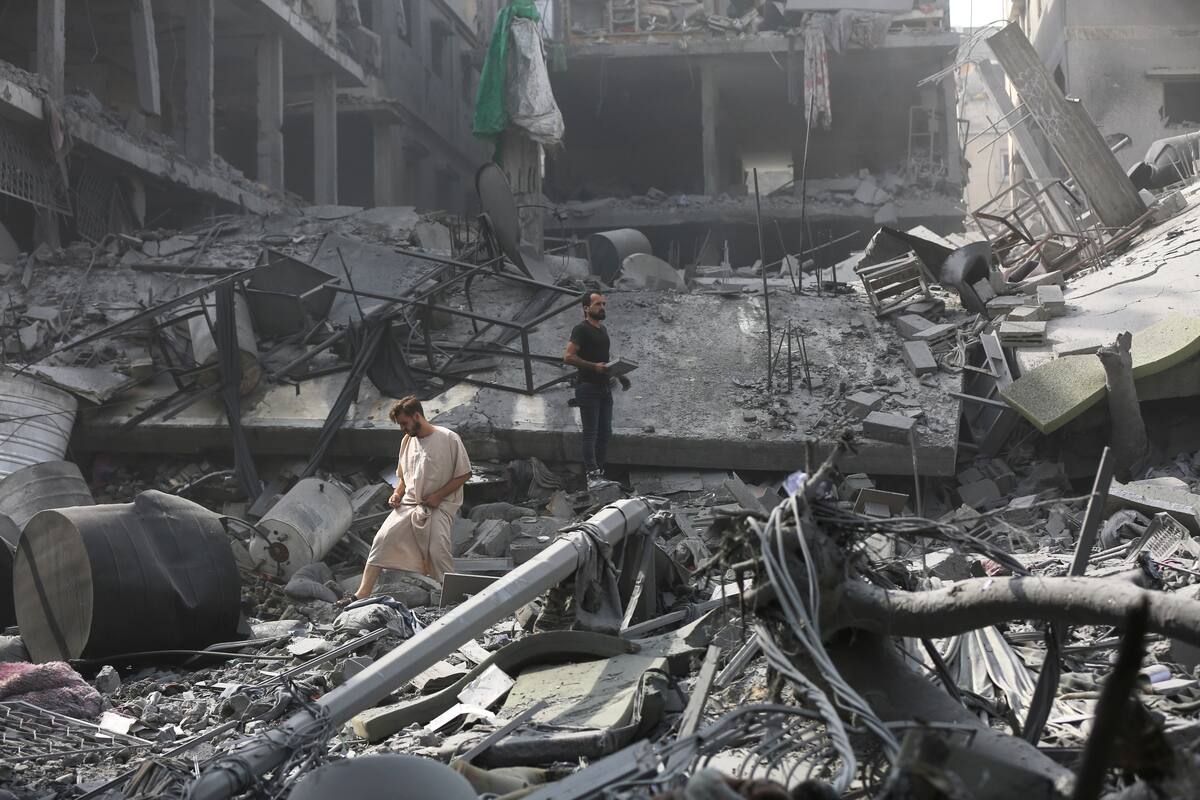 Palestinos inspeccionan los daños de edificios destruidos tras los ataques aéreos israelíes sobre Ciudad de Gaza, el lunes 23 de octubre de 2023. (AP Foto/Abed Khaled)