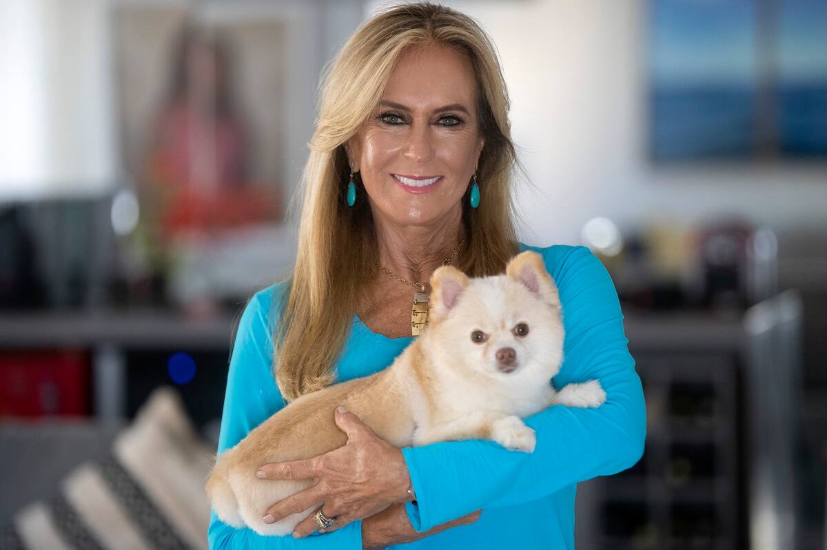 Helo Pinheiro posa con su perro Cookie en su casa en Sao Paulo, Brasil, el martes 11 de mayo de 2021. Pinheiro es la musa original de la canción de bossa nova "La chica de Ipanema" de Antônio Carlos Jobim y Vinicius de Moraes lanzada en la década de 1960. (AP Foto/Andre Penner)