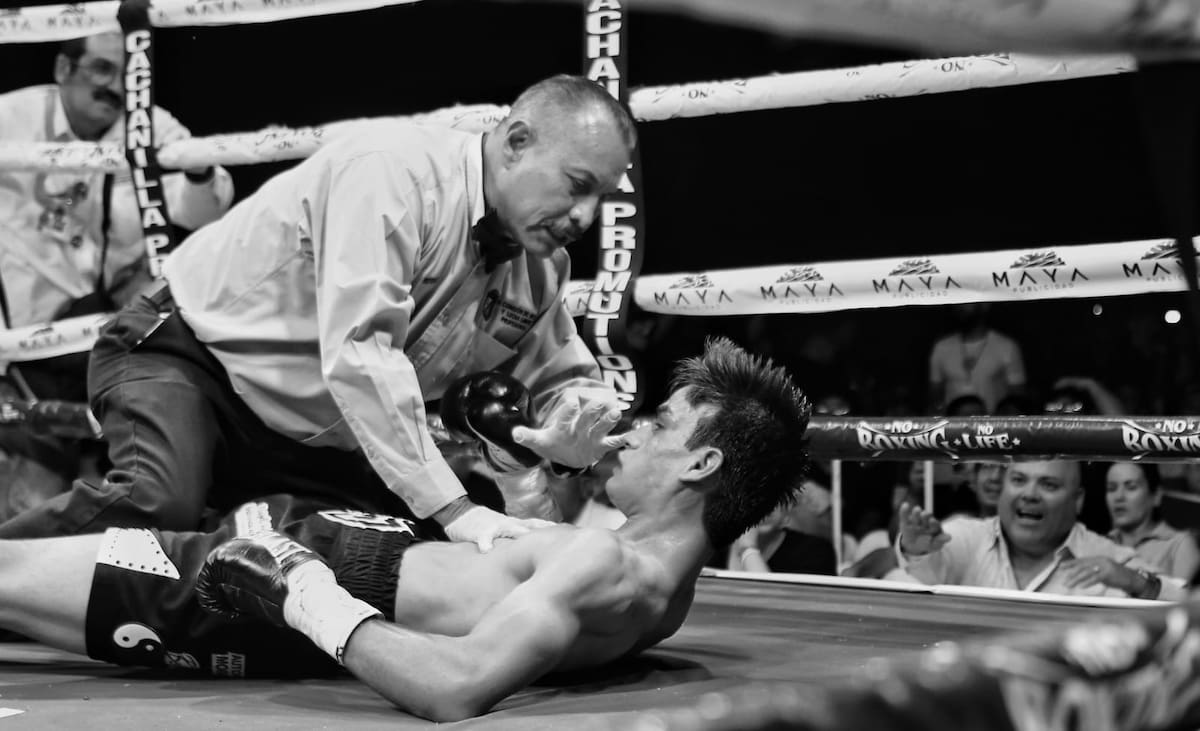 Jesús “El Muñeco” Zazueta cae a la lona durante su combate frente al sonorense José Islas Togawa en una función de boxeo realizada en el Bosque y Zoológico de la Ciudad, en Mexicali. (Foto: Saúl Martínez)