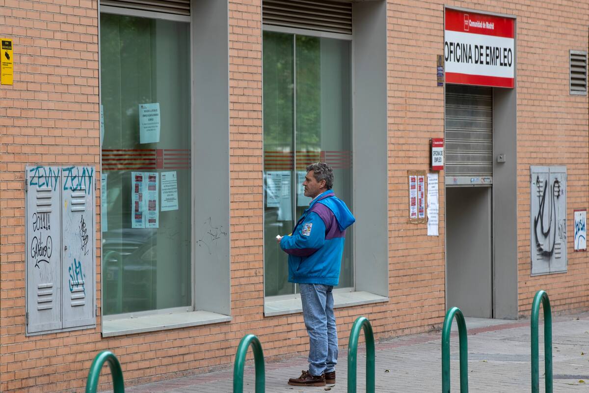 Un hombre lee los avisos en una oficina de empleo en Madrid, España, el martes 28 de abril de 2020. (AP Foto/Paul White, File)
