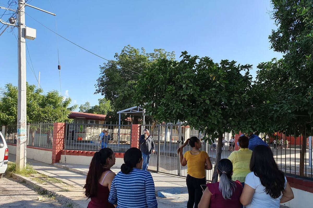 Alumnos cargan mesabancos de un salón a otro por falta de espacio; padres se manifiestan