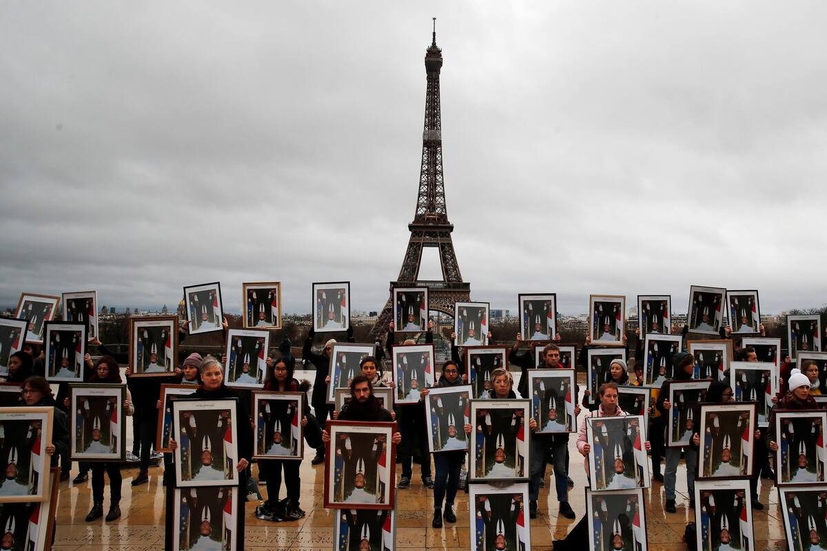 Activistas ponen a retrato de Macron de cabeza durante manifestación