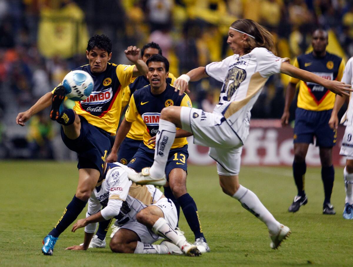 America's Angel Reyna, left, controls the ball as Pumas' Leandro Augusto defends during a Mexican soccer league match in Mexico City, Wednesday, April 14, 2010. (AP Photo/Claudio Cruz)
