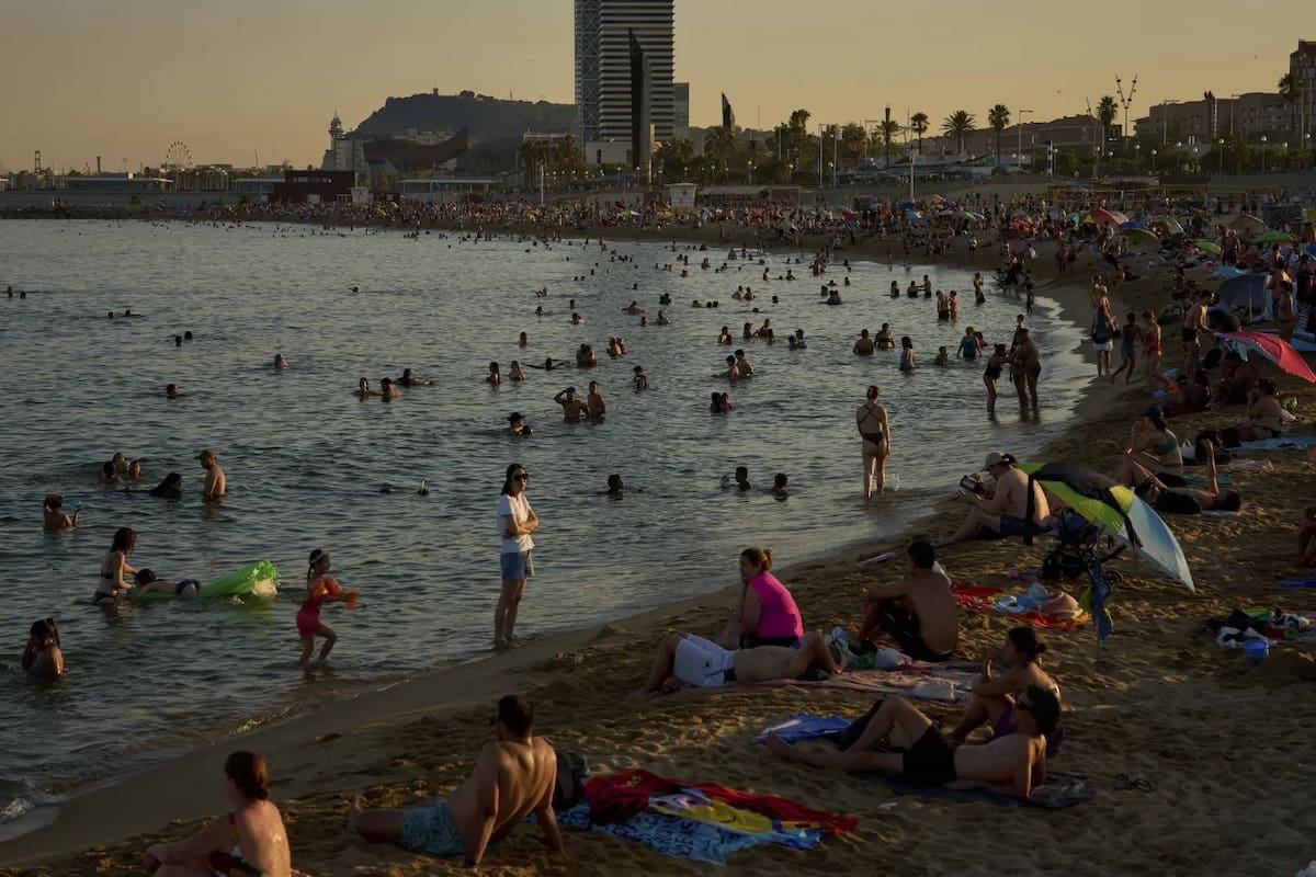 Bañistas se refrescan en el agua en una playa durante un día caluroso en Barcelona, España, el domingo 29 de junio de 2025. | Crédito: AP/Emilio Morenatti)