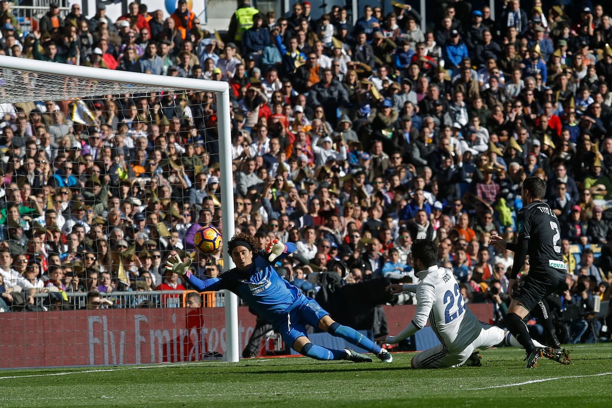 Real Madrid's Francisco Roman "Isco", center, scores past Granada's goalkeeper Guillermo Ochoa, left, during the Spanish La Liga soccer match between Real Madrid and Granada at the Santiago Bernabeu stadium in Madrid, Saturday, Jan. 7, 2017. Isco scored twice in Real Madrid's 5-0 victory. (AP Photo/Francisco Seco)