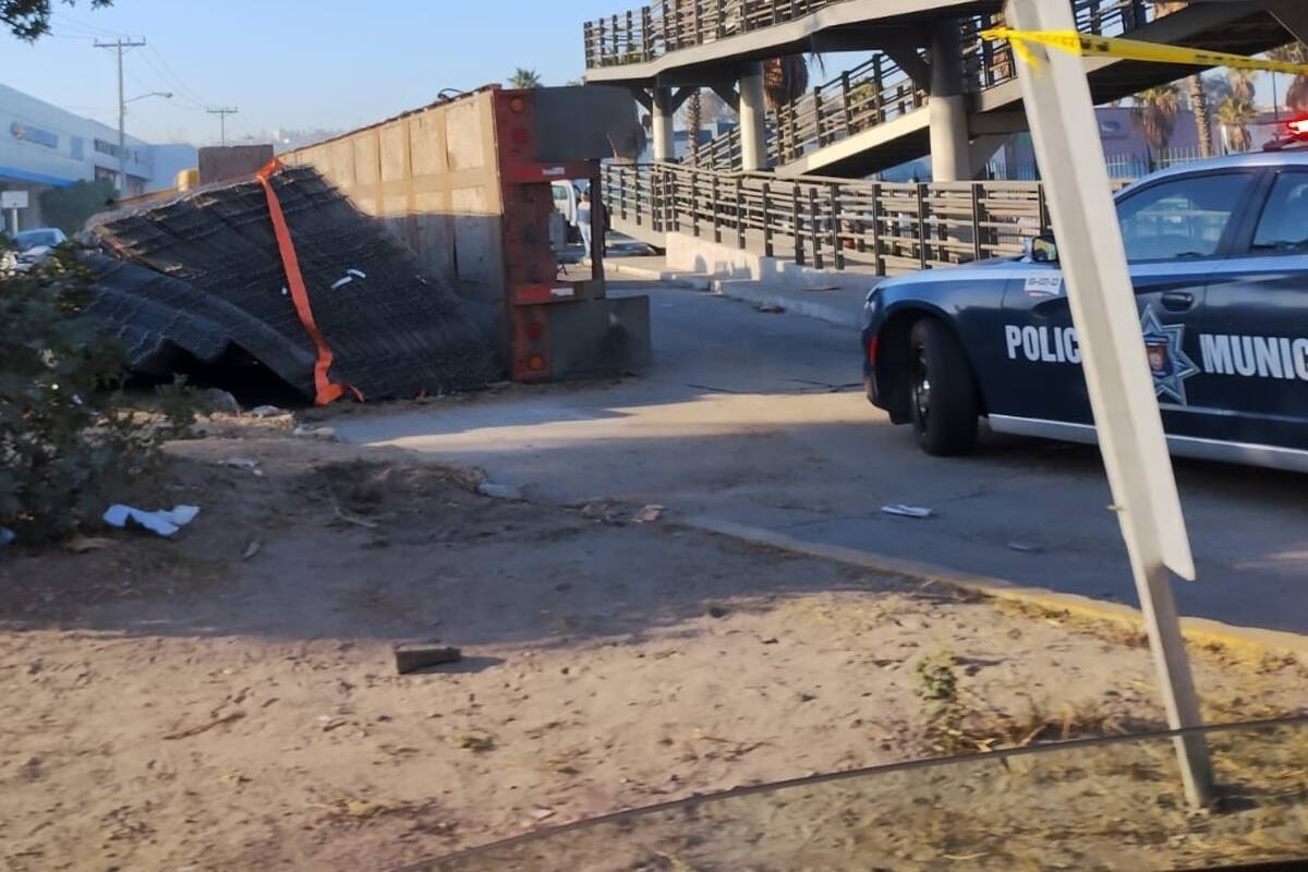 Tráiler que transportaba varillas se vuelca cerca de puente peatonal