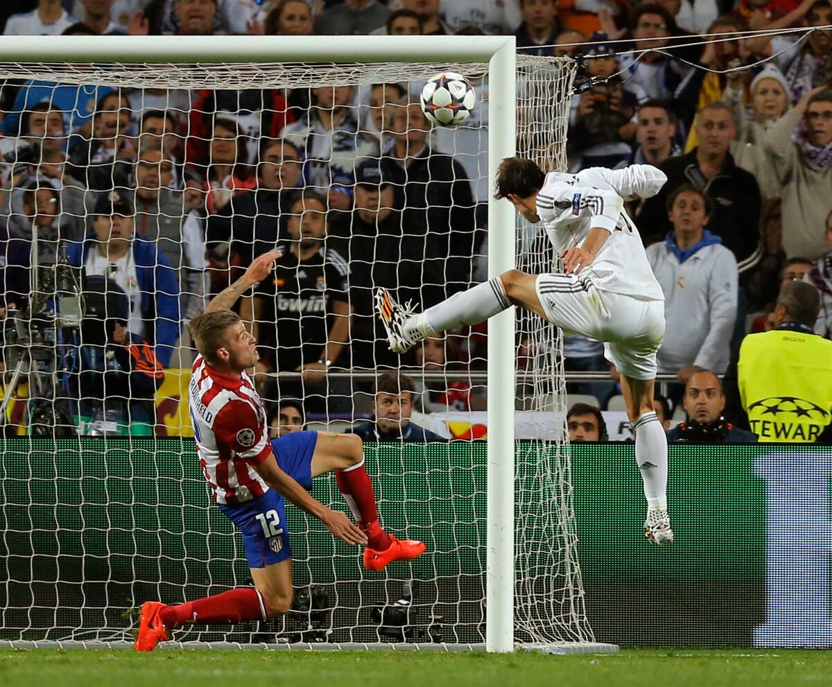 Real's Gareth Bale, right scores his side's 2nd goal, during the Champions League final soccer match between Atletico de Madrid and Real Madrid, at the Luz stadium, in Lisbon, Portugal, Saturday, May 24, 2014. (AP Photo/Daniel Ochoa de Olza)