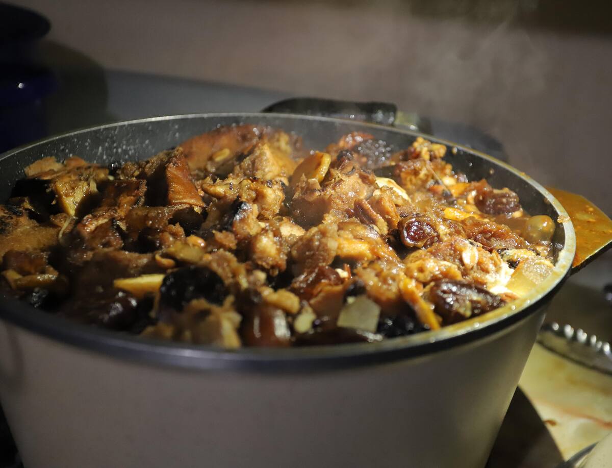 Al finalizar las capas de pan y frutos secos, le agrega la miel y la deja a fuego lento.