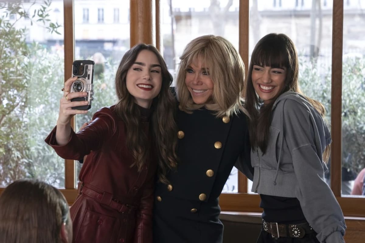 Foto tomada por Stephanie Branchu para Netflix el 2 de abril de 2024, en París. Lily Collins (izquierda), Brigitte Macron, esposa del presidente de Francia Emmanuel Macron (centro), y Thalia Besson posan para una selfie durante la filmación del episodio 407 de la serie de Netflix “Emily in Paris”. | Crédito: AP vía Netflix