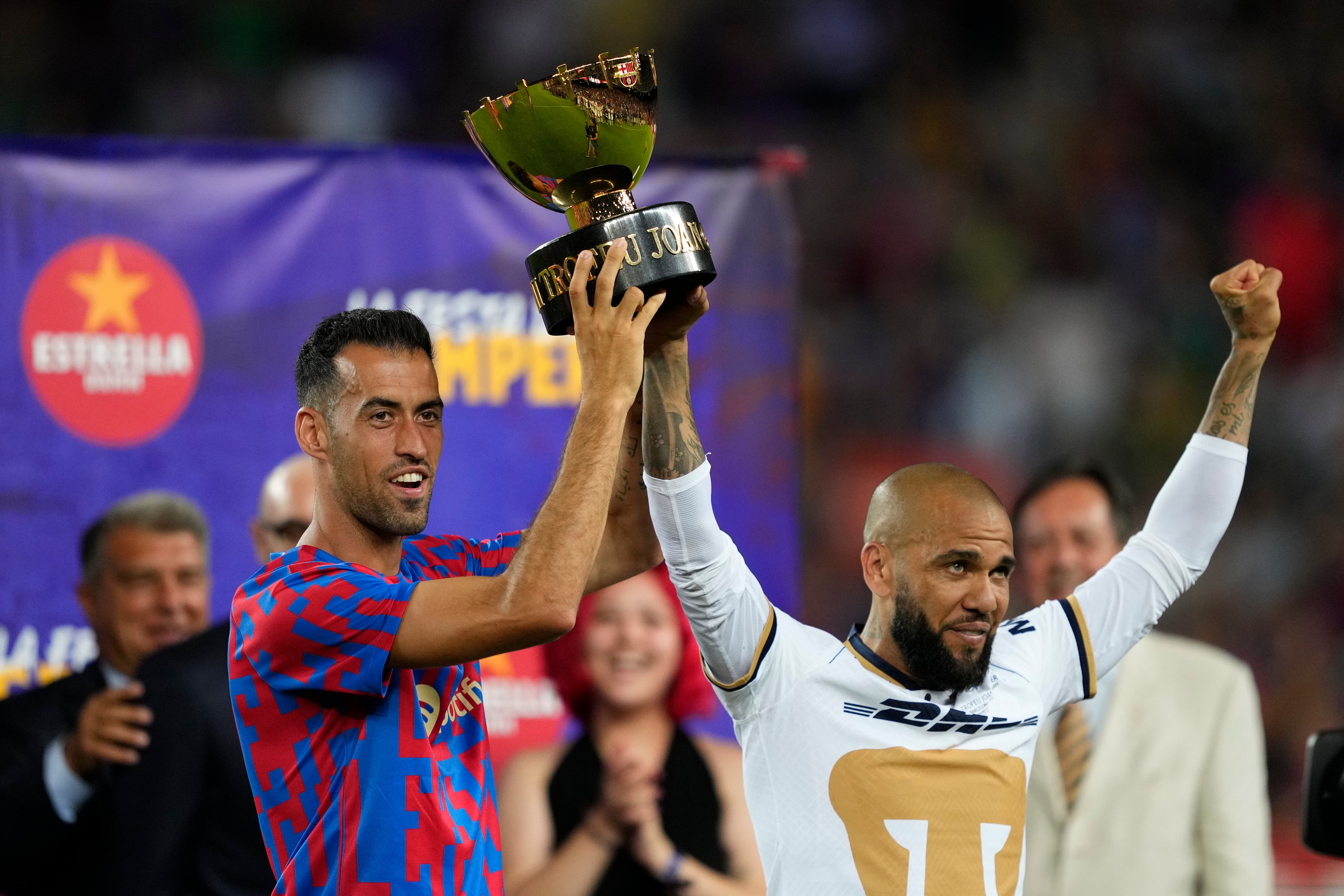 BARCELONA, 07/08/2022.- El capitán del FC Barcelona Sergio Busquets (i) posa con la copa junto al exjugador Dani Alves, al término del partido del trofeo Joan Gamper ante Pumas disputado este domingo en el Camp Nou. EFE/Alejandro García