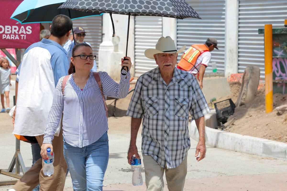 Dos personas se cubren con sombrilla en Hermosillo por el calor. | Gerardo D. Gonsález