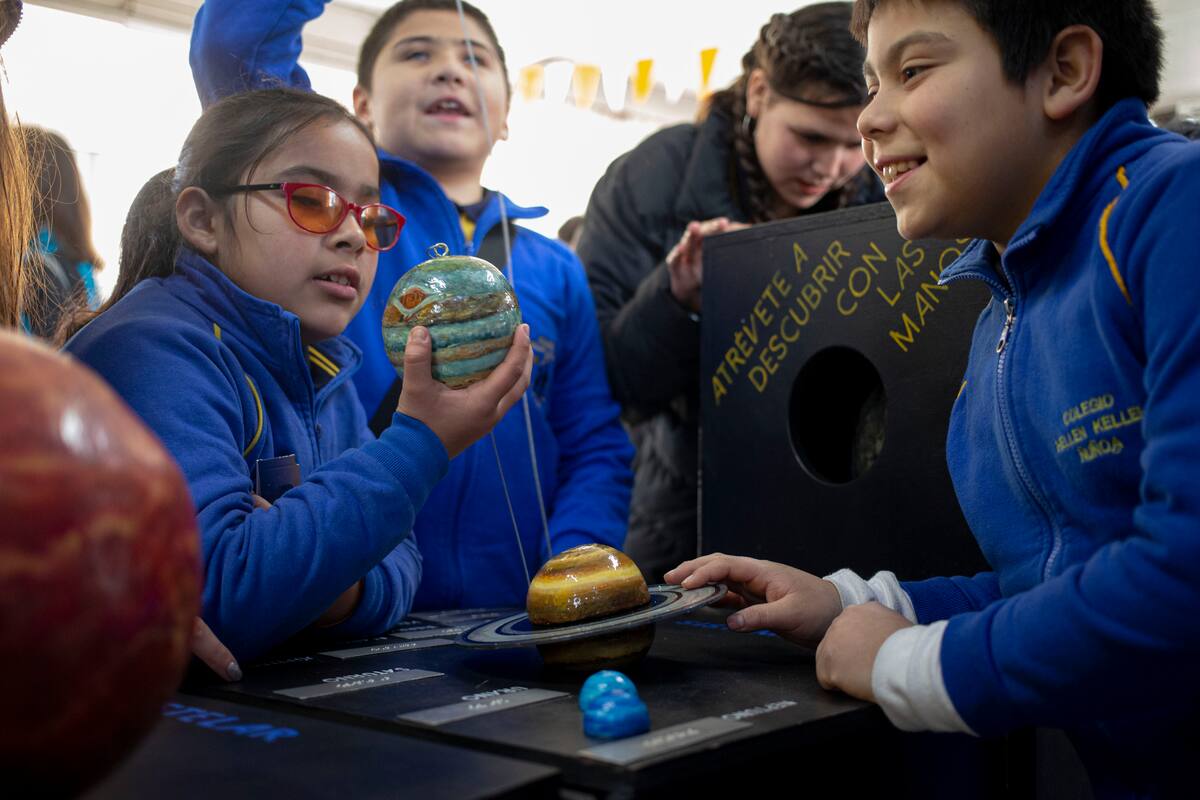 Niños ciegos participan en una experiencia sensorial con herramientas creadas por la NASA y la Universidad de Edimboro para experimentar un eclipse, durante un evento en la escuela Helen Keller en Santiago de Chile, el martes 25 de junio de 2019. (AP Foto / Esteban Félix)