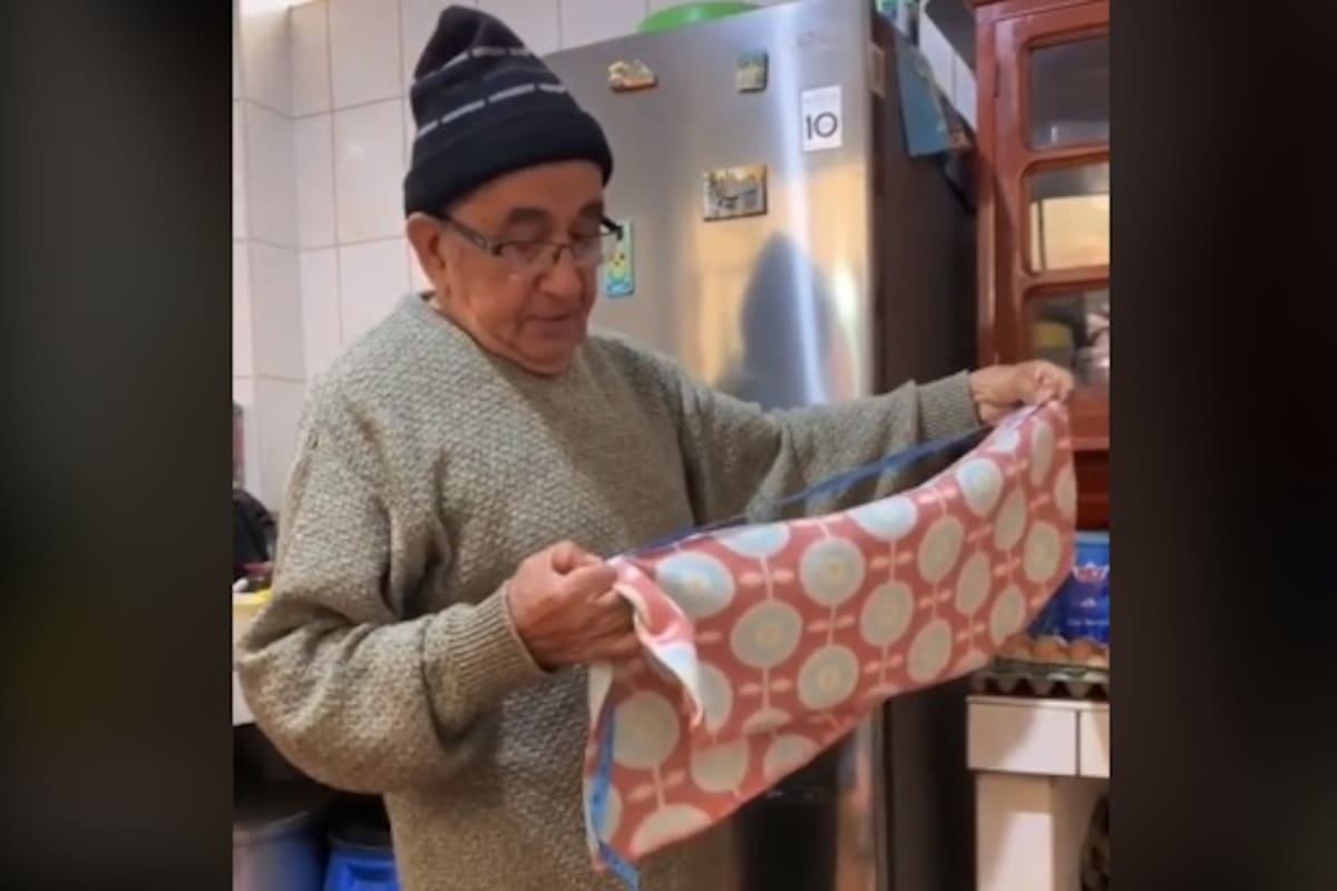Tierno abuelito cose un suéter para su perro