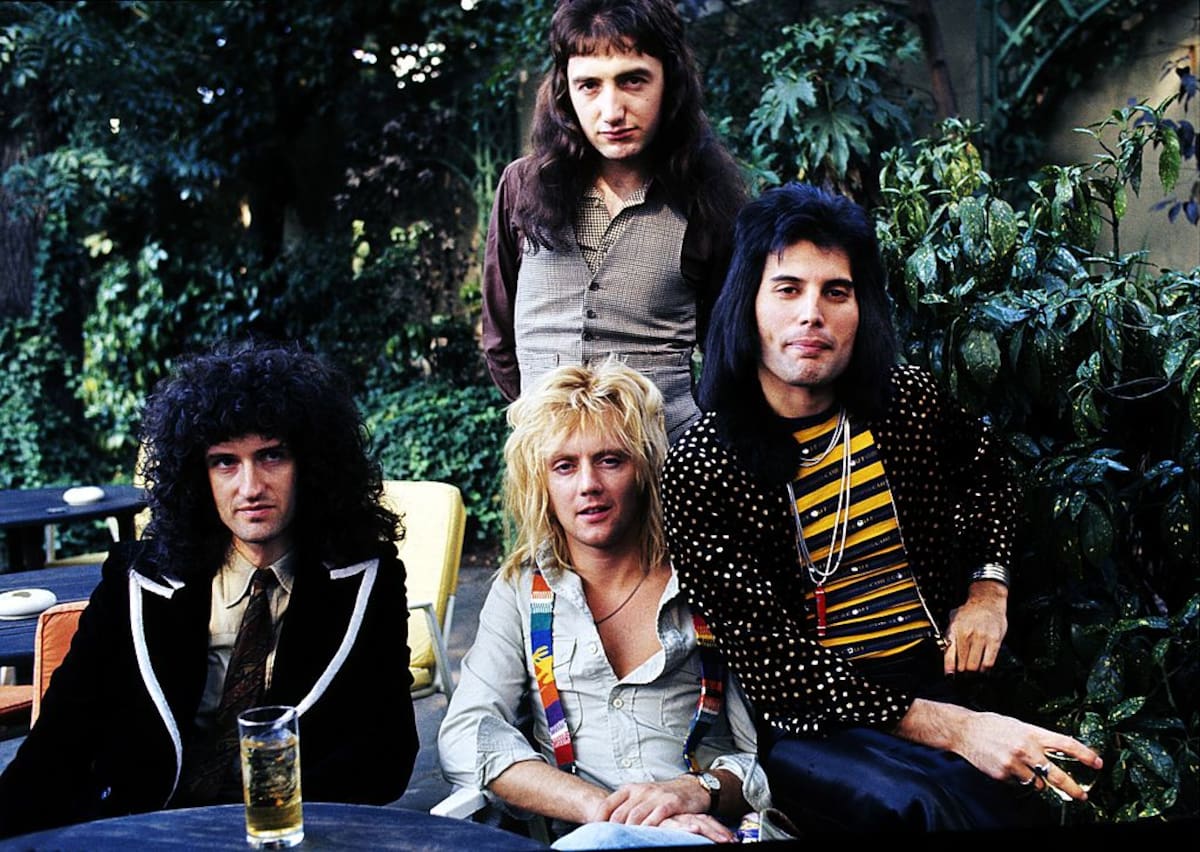 LONDON, ENGLAND - SEPTEMBER 08: (L-R) Brian May, John Deacon (standing), Roger Taylor and Freddie Mercury of British rock group Queen at Les Ambassadeurs where they were presented with silver, gold and platinum discs for sales in excess of one million of their hit single 'Bohemian Rhapsody', which was No 1 for 9 weeks on September 8, 1976 in London, England. (Photo by Anwar Hussein/Getty Images)