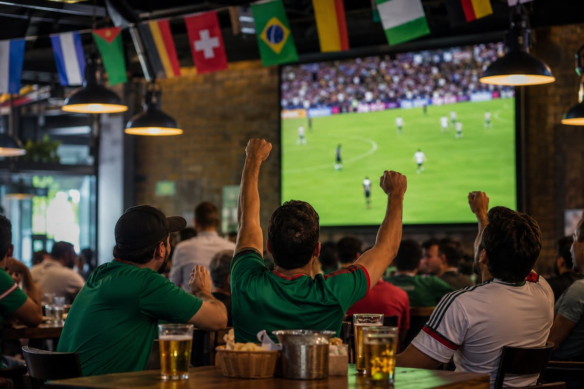 Restaurantes y bares podrán proyectar los partidos del Mundial 2026, pero deberán cumplir con las reglas de la FIFA y la legislación mexicana para evitar multas que pueden superar los 586 mil pesos. (Foto: Generada con IA)