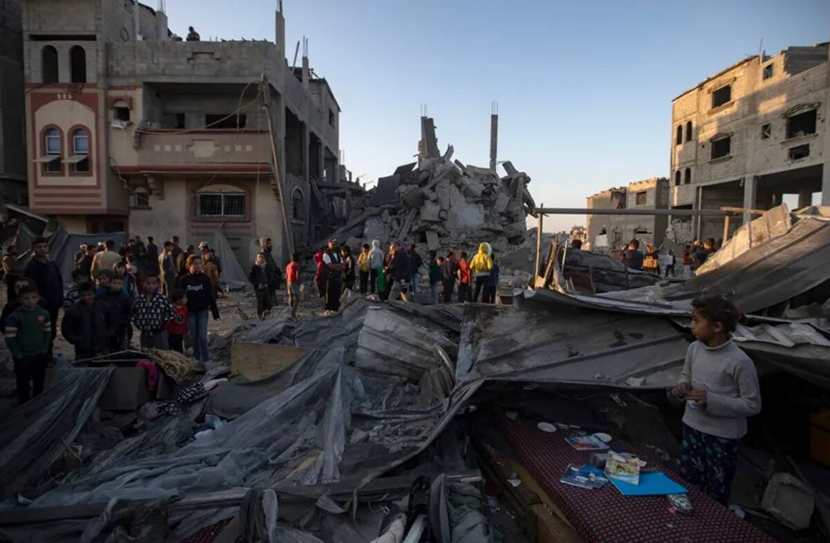 Palestinos inspeccionan los escombros de un edificio destruido tras un ataque aéreo israelí, en Khan Yunis, en el sur de la Franja de Gaza. EFE/EPA/Haitiham Imad