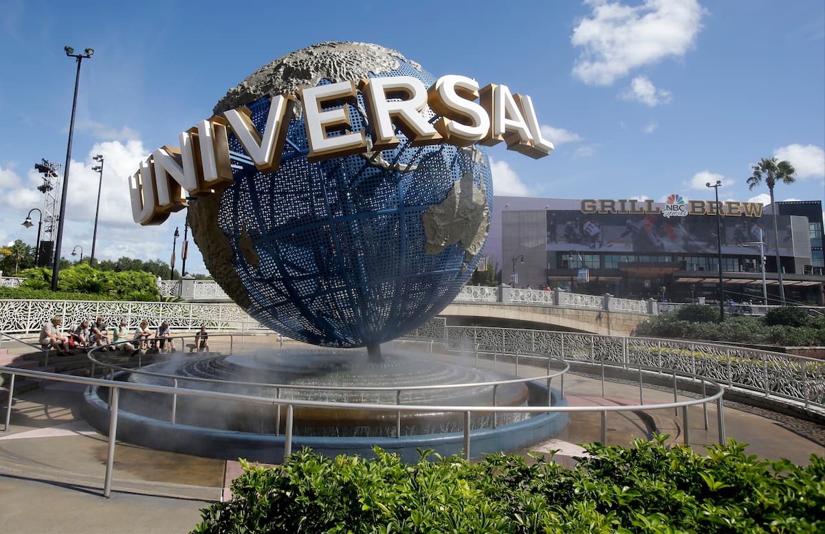 Unos visitantes toman una pausa bajo la brisa del globo en Universal Studios City Walk en Orlando, Florida, el 22 de octubre de 2015. (AP Foto/John Raoux, File)