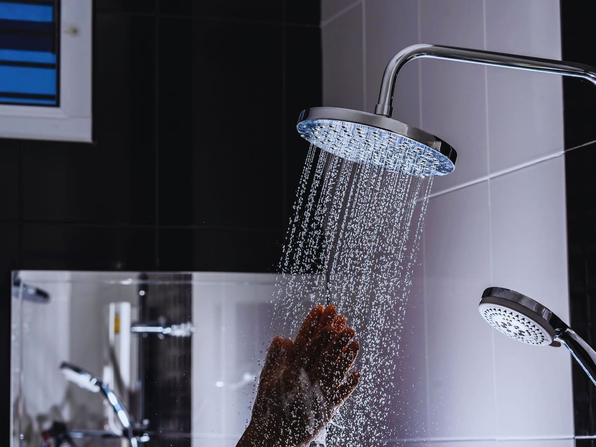 Incorporar una ducha a oscuras puede funcionar como un ritual nocturno que facilita la transición del estado de alerta al de descanso. | Crédito: Canva