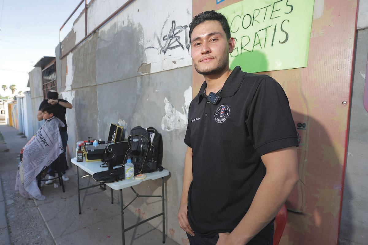 Desde una banqueta de Villa del Real, Juan ofrece cortes gratis y persigue el sueño de abrir su propia barbería