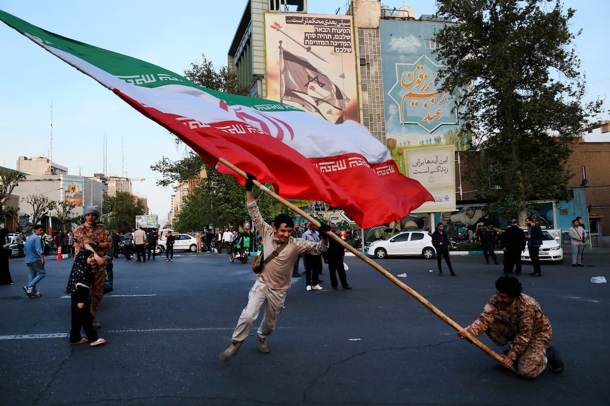 Manifestantes ondean una enorme bandera iraní en su reunión antiisraelí frente a la plaza Felestin (Palestina), en Teherán, Irán, el lunes 15 de abril de 2024. (Foto AP/Vahid Salemi)