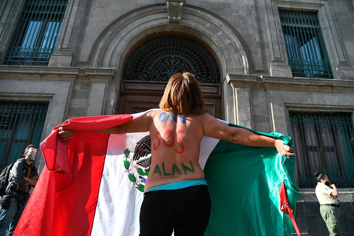 Mujer envuelta en bandera frente a Palacio Nacional exige justicia