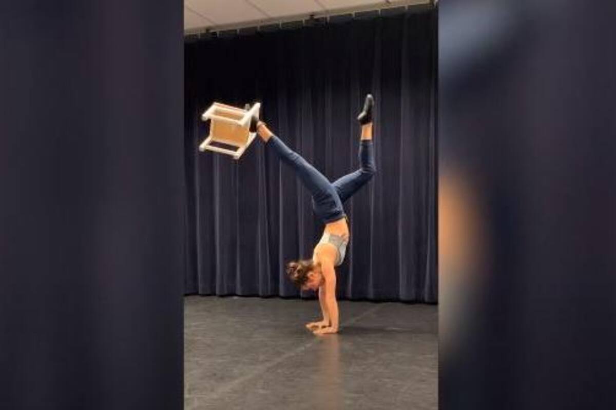 Acróbata aparece en video parada de manos y levantando una silla con un pie