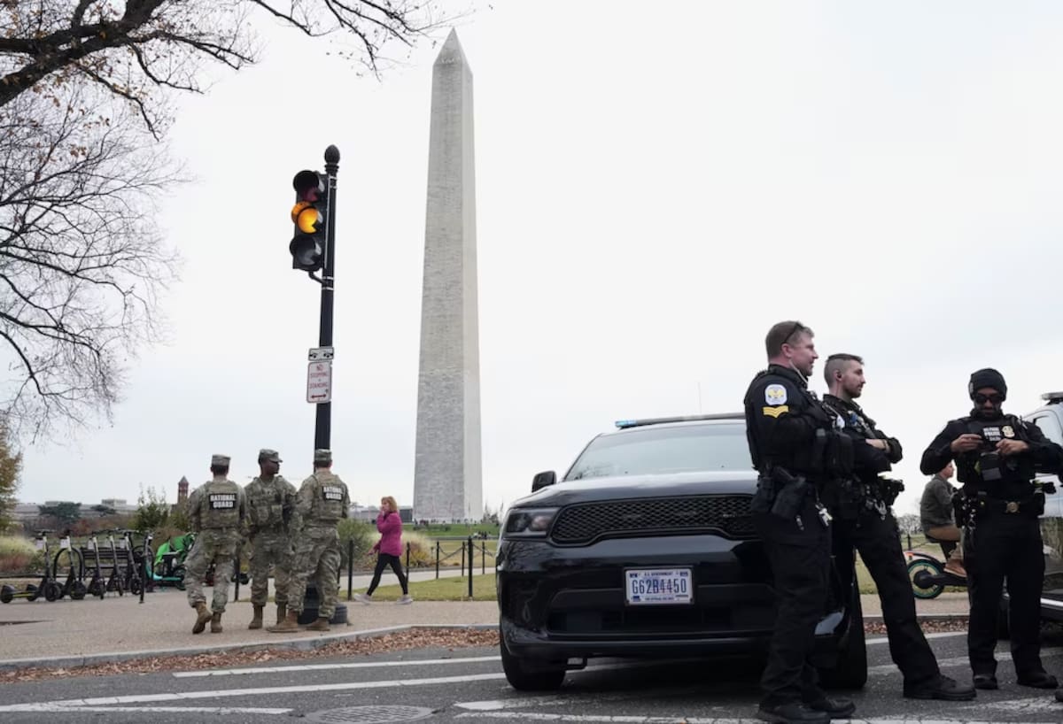 U.S. Park Police and National Guard members stand with the Washington Monument in the background as people protest against the Trump administration outside the White House in Washington, D.C., U.S., November 15, 2025.