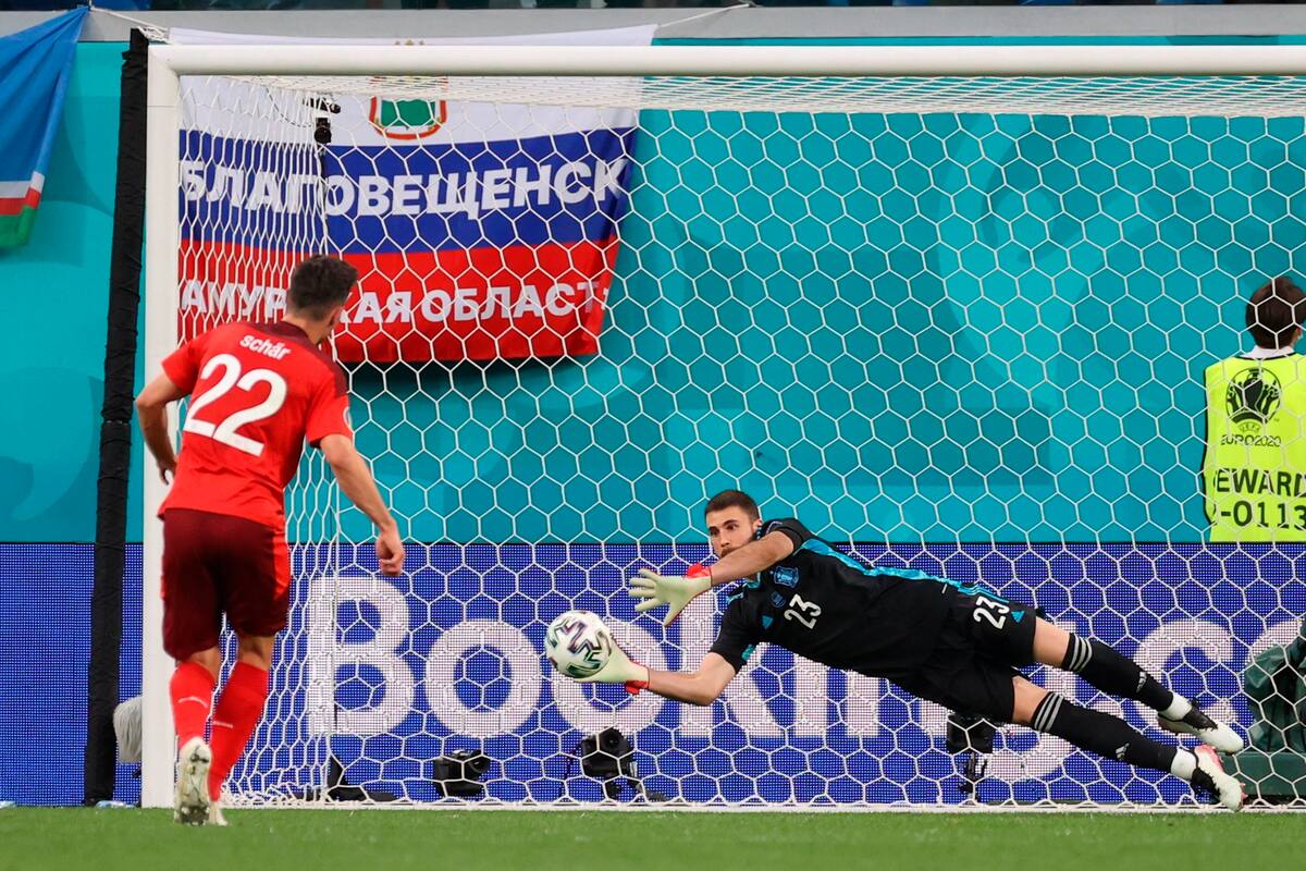 El portero de España Unai Simón (d) detiene el penalti lanzado por el defensa de Suiza Fabian Schar (i) durante la tanda del encuentro de cuartos de final de la Eurocopa 2020 entre Suiza y España, en el estadio Krestovski, en San Petersburgo, Rusia. EFE/ Kiko Huesca