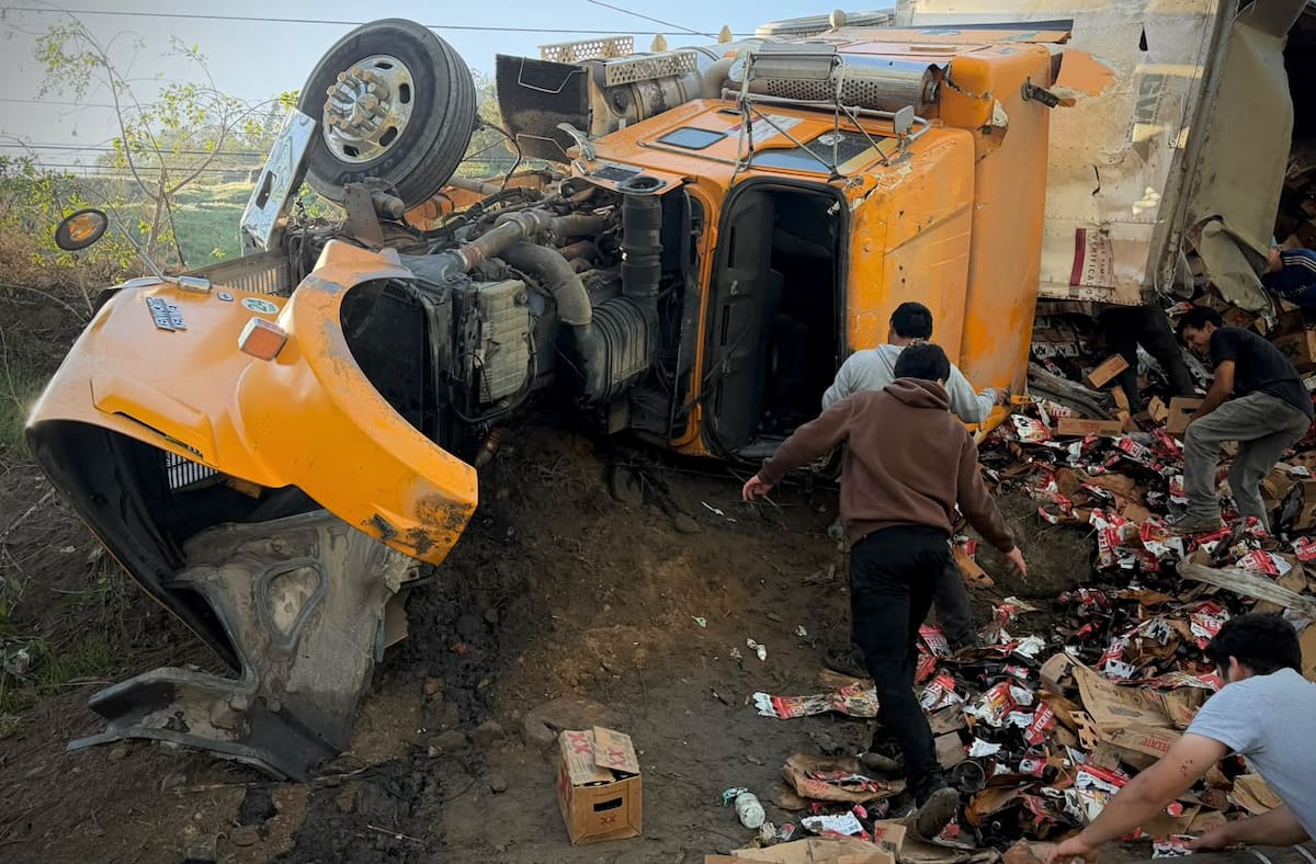 Personas cargaron cerveza en baldes y tinas tras la volcadura en Granjas Buenos Aires. Foto: Border Zoom