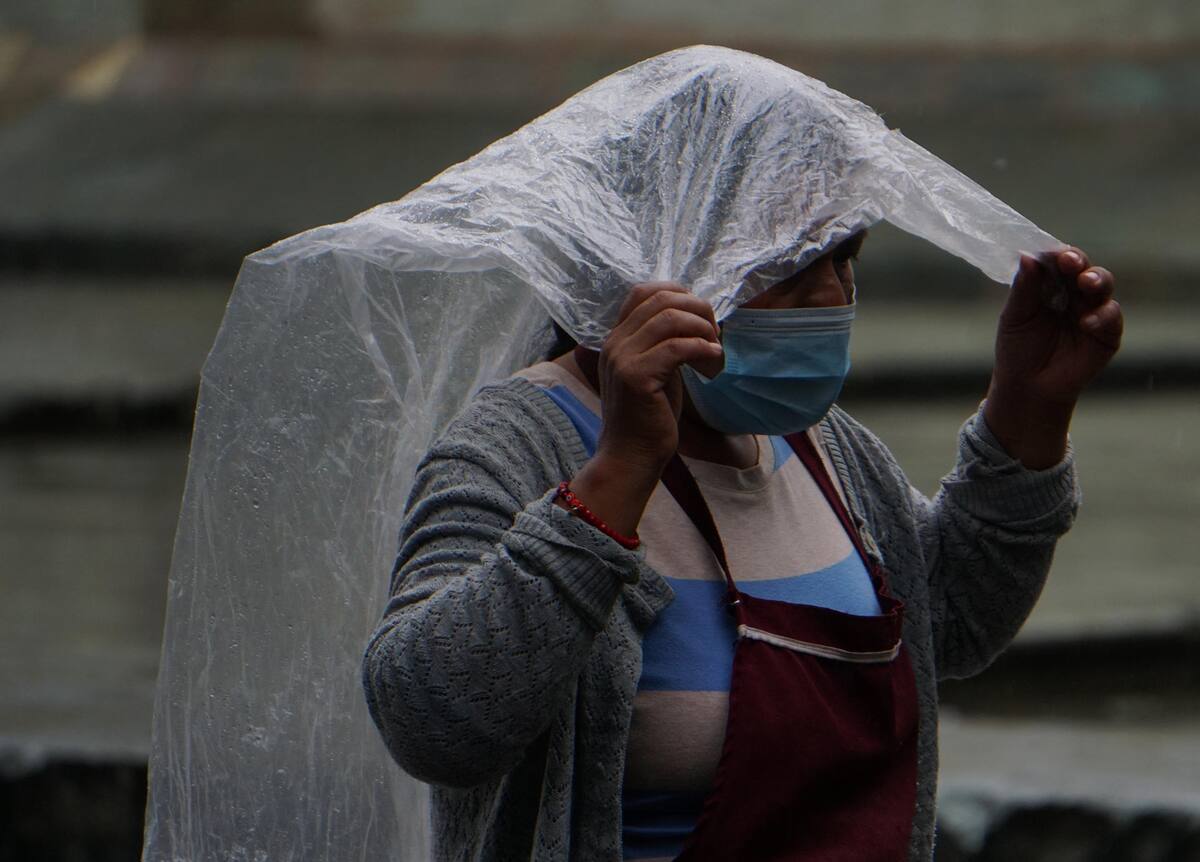 Una mujer se protege de la lluvia en el estado de Oaxaca (México). Fotografía de archivo. EFE/Daniel Ricardez