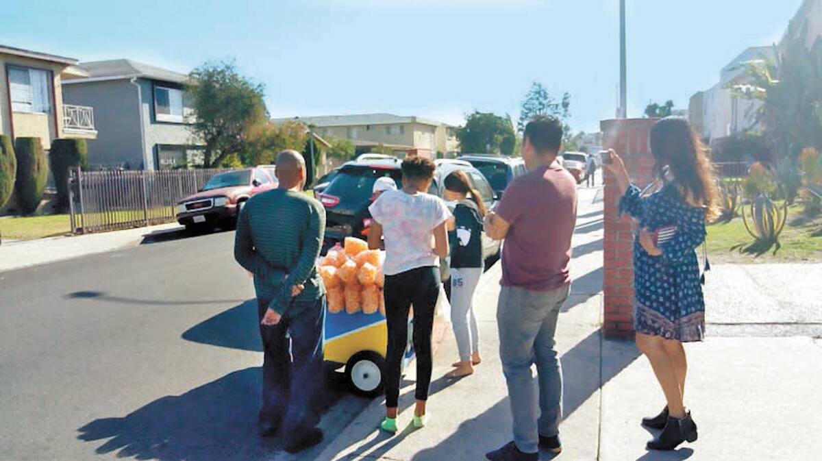 LOS ÁNGELES, California, agosto 11 (EL UNIVERSAL).- Todos los días, don Víctor Pérez recorre las casas y departamentos del oeste de Los Ángeles. Empuja un carrito azul de madera y a cada tanto aprieta una corneta con la que invita a los vecinos a comprar un poquito de nostalgia: elotes, esquites, chicharrones y raspados de a dos y tres dólares. Foto: Agencia EL UNIVERSAL
