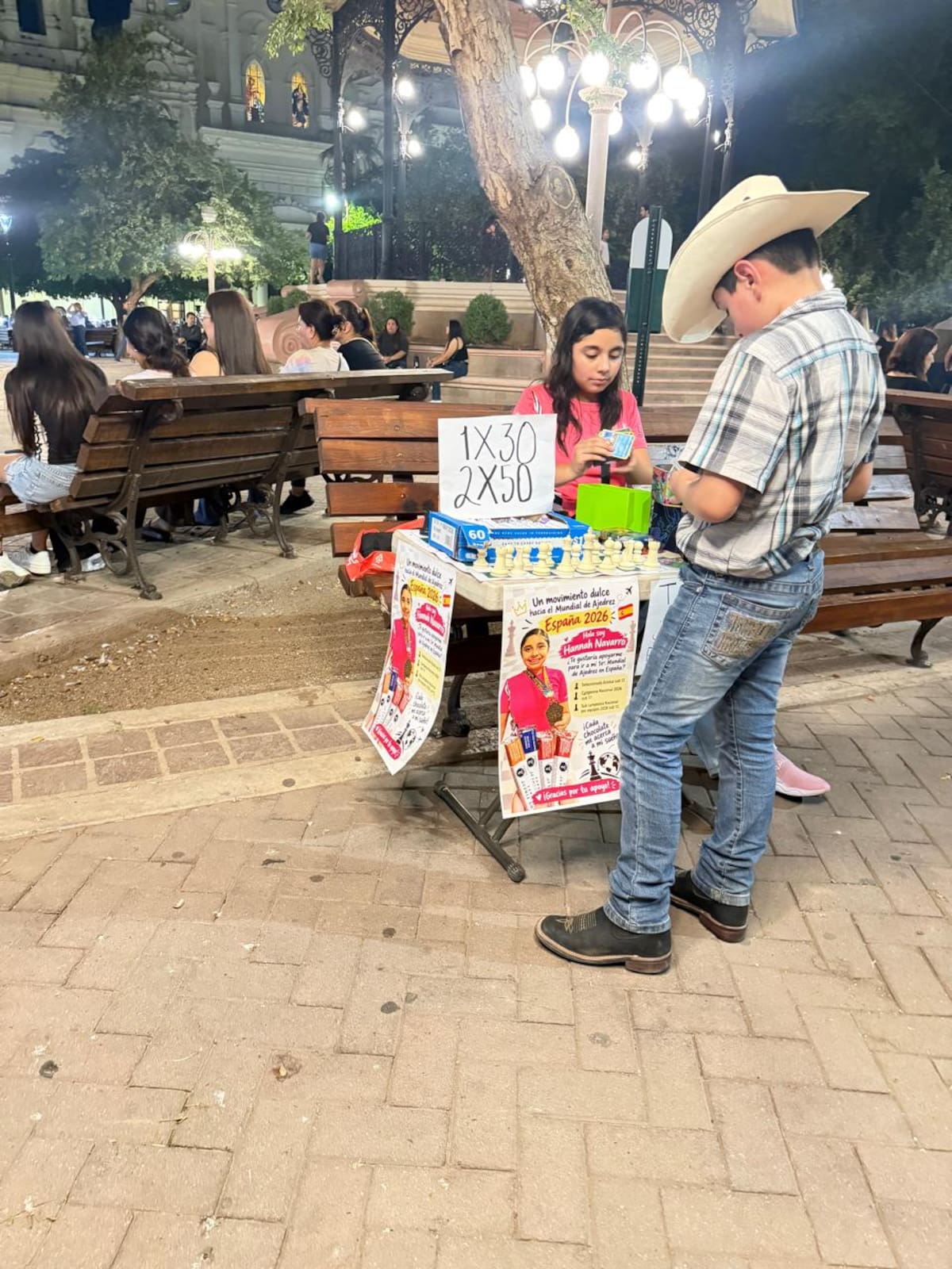 Hannah busca reunir fondos con un puesto de venta de chocolates, cartas Pokemon, y partidas de ajedrez gratis en la Plaza Zaragoza | Cortesía