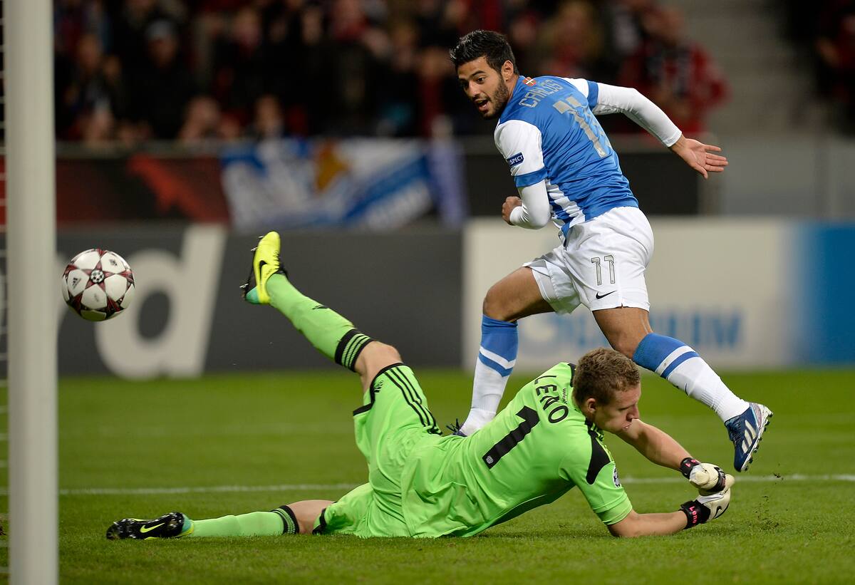 Carlos Vela, de la Real Sociedad, a la derecha, anota un gol ante el portero del Leverkusen, Bernd Leno, durante el partido del Grupo A de la Liga de Campeones entre el Bayer Leverkusen y la Real Sociedad en Leverkusen, Alemania, el miércoles 2 de octubre de 2013. (Foto AP/Martin Meissner)