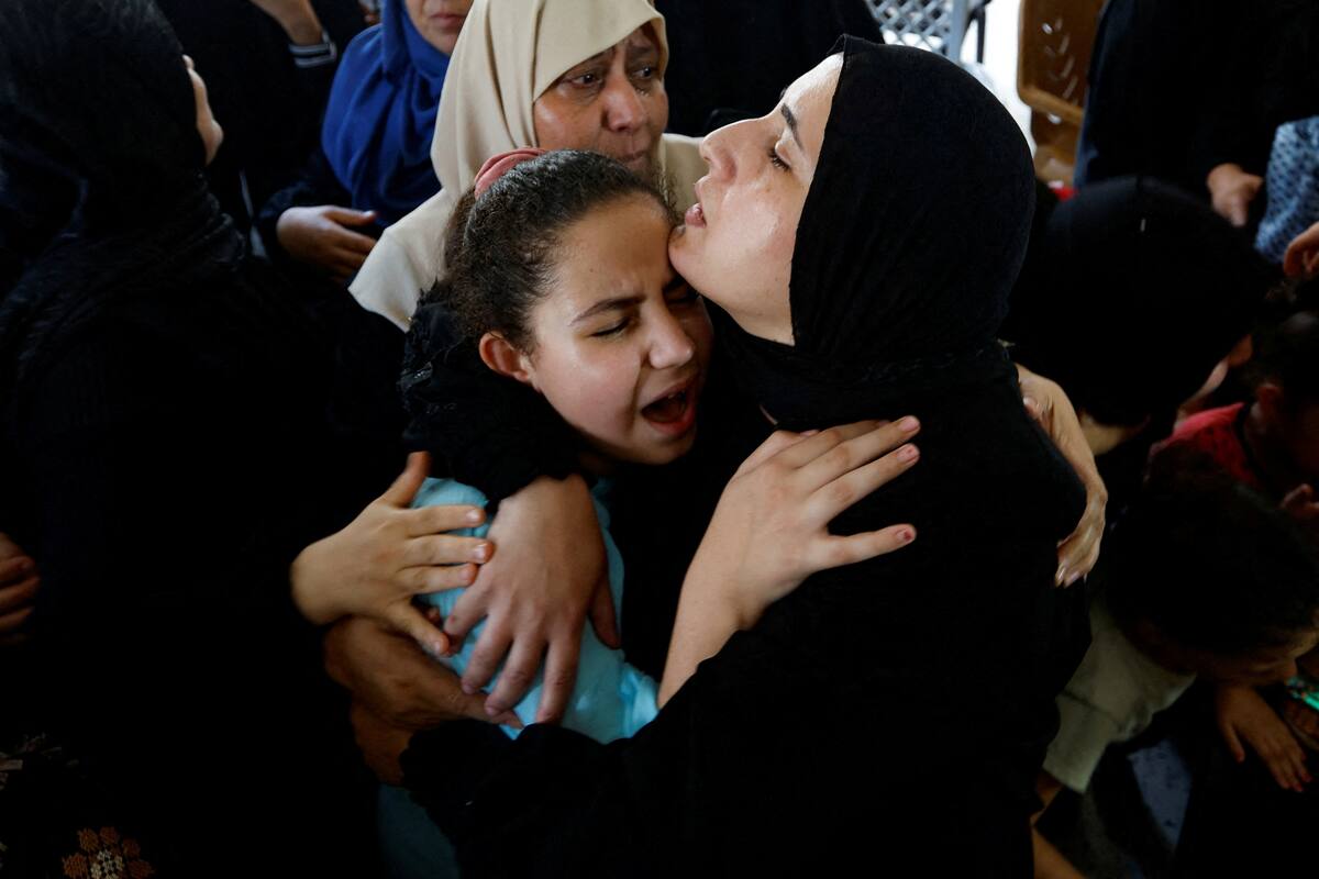 La esposa y la hija del alto comandante palestino del grupo militante Yihad Islámico Khaled Mansour, quien murió en los ataques aéreos israelíes, reaccionan durante el funeral en Rafah, en el sur de la Franja de Gaza, el 7 de agosto de 2022. REUTERS/Ibraheem Abu Mustafa