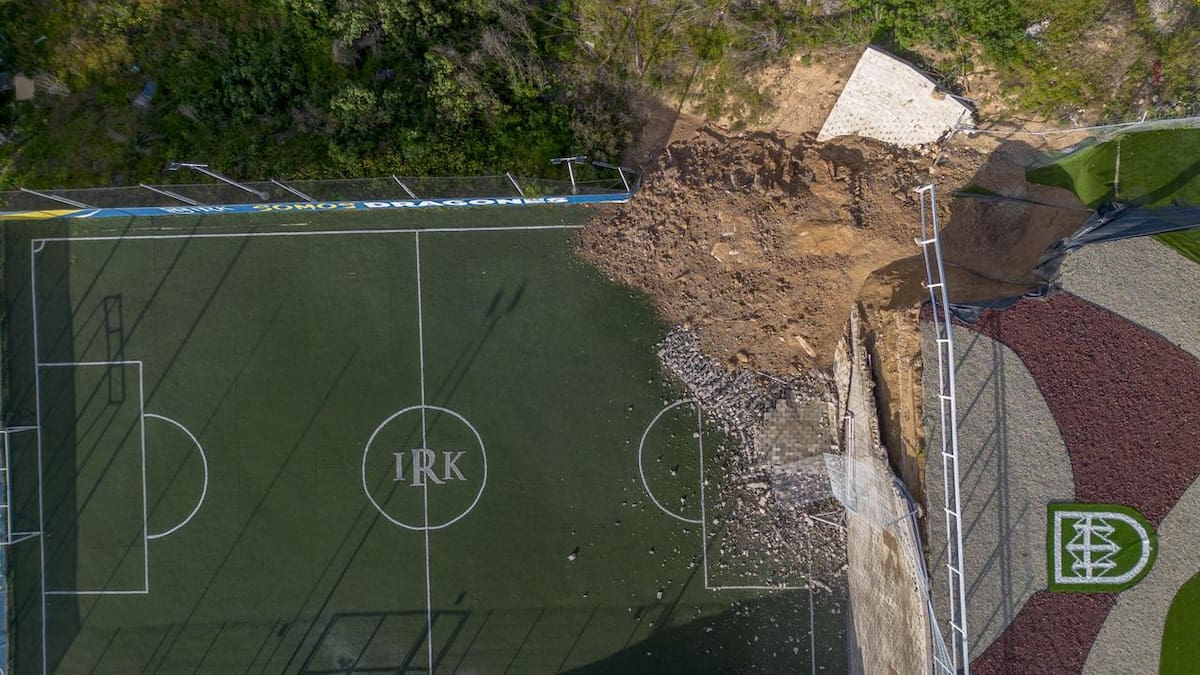 Un deslave de tierra provocado por las recientes lluvias ocasionó el colapso de una barda que dividía dos canchas deportivas del Instituto Kolbe, dejando un cúmulo de tierra, rocas y fragmentos de concreto. Foto: Border Zoom